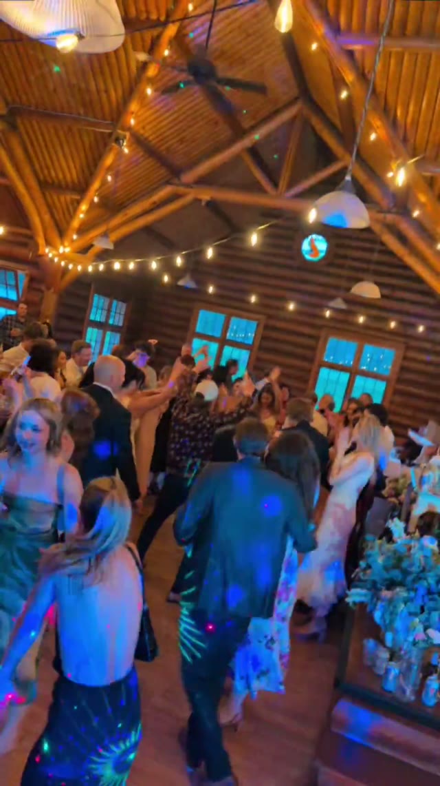 A wall-to-wall dancing crowd in a log lodge hall